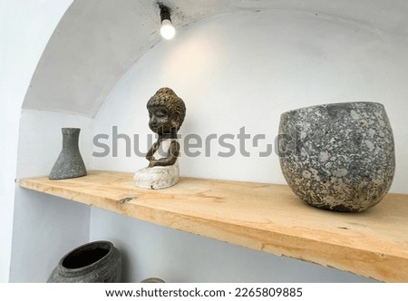 Small statue decorations for table and interior, little buddha statue modern simplistic house environment with several pottery and wooden table