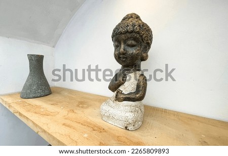 Small statue decorations for table and interior, little buddha statue modern simplistic house environment with several pottery and wooden table
