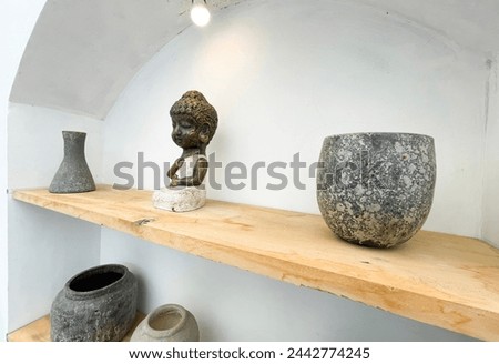 Small statue decorations for table and interior, little buddha statue modern simplistic house environment with several pottery and wooden table