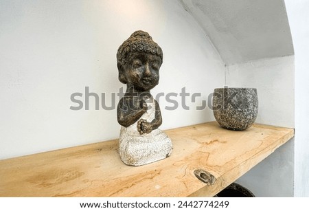 Small statue decorations for table and interior, little buddha statue modern simplistic house environment with several pottery and wooden table