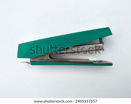 Small stepler on white background in green color