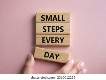 Small Steps Every Day symbol. Wooden blocks with words Small Steps Every Day. Beautiful pink background. Businessman hand. Business and Small Steps Every Day concept. Copy space. - Shutterstock ID 2360012235