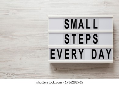 'Small steps every day' words on a modern board on a white wooden background, top view. Overhead, from above, flat lay. Copy space. - Shutterstock ID 1736282765
