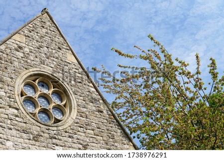 A small stone building with a pretty glass window at Wandsworth Cemetery, which is located on Magdalen Road in South West London.  Image has copy space.