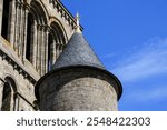 A small stone and tiled turret with a golden decoration on top