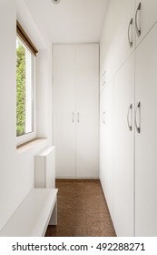 Small Storage Room With Simple White Furniture And Window