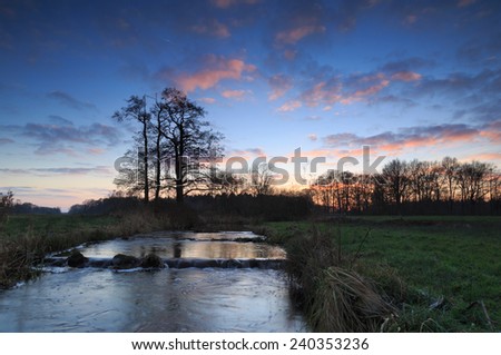 Small stream with fish pass during a colorful sunset.