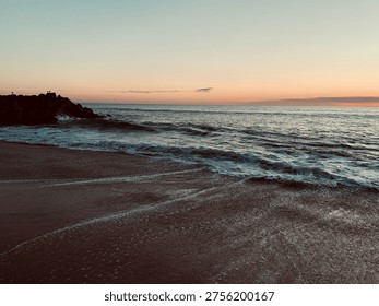 Small streams of water flowing back to the sea, carving tiny rivulets in the wet beach sand.