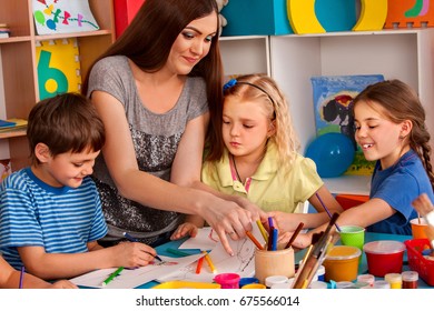 Small Students With Teacher Finger Painting In Art School Class. Break School In Painting Class. Mom And Kids At Home. Modern Methods Of Teaching Children Through Game.