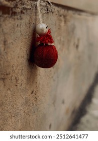 small stuffed red object hanging from a wall