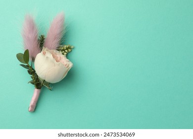 Small stylish boutonniere on turquoise background, top view. Space for text - Powered by Shutterstock