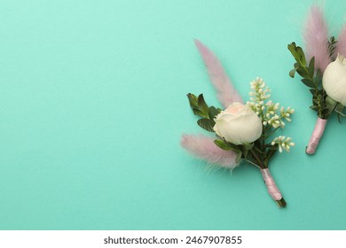Small stylish boutonnieres on turquoise background, flat lay. Space for text - Powered by Shutterstock