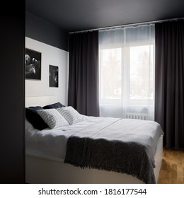 Small and stylish designed bedroom with modern black ceiling and white double bed - Powered by Shutterstock