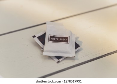 Small Sugar Packet On The White Wooden Table