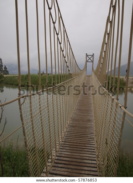 A small suspension bridge as a\
bridge over a mountain lake, Austria, Alpy, Wagrain,\
Grafenberg