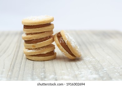 small sweet appetizer with white flour and white delicacy alfajor limeño on a wooden base and rustic white background - Shutterstock ID 1916302694