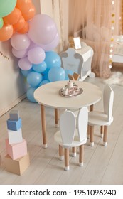 Small Table And Chairs With Bunny Ears In Children's Room Interior. Rainbow, Colorful Balloon Arch, Decoration In Honor Of The Holiday, Birthday, Party