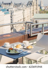 Small table with served breakfast on balcony