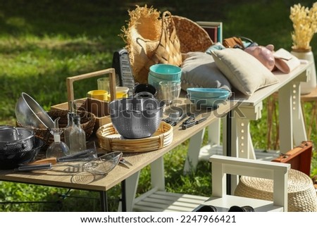 Small tables with many different items on garage sale outdoors