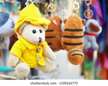 A small teddy bear in a yellow jacket and hat.