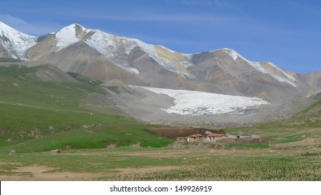 Small Tibetan village and glaciers on holy snow mountain Anymachen on Tibetan Plateau, Qinghai, China