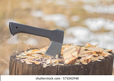 Small Tourist Axe Hatchet On Stump With Sawdust Shavings Outdoors. Carpentry Woodwork Concept