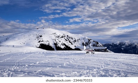 A small tourist plane is preparing to take off from a snow-covered meadow in the high mountains in the Bergamo area orobie monte pora
 - Powered by Shutterstock