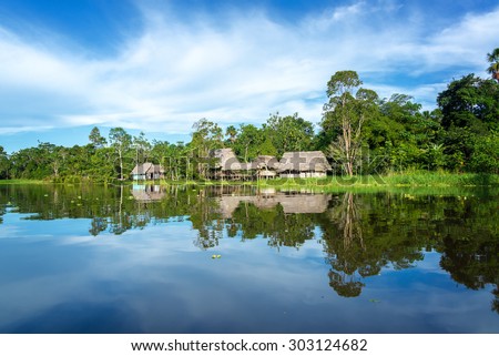Small town in the Amazon rain forest reflected in the Yanayacu River near Iquitos, Peru