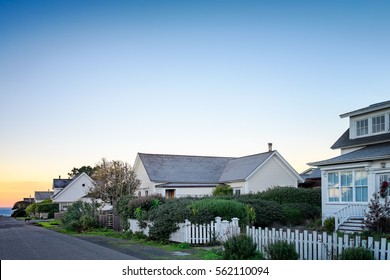 Small Town America Houses With White Picket Fences In Sunrise Light. Background For Old Fashioned Nostalgic American Town Concept. Morning In America. Copy Space