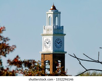 Small Town America Majestic Clock Tower With Autumn Foliage On A Blue Sky Day.