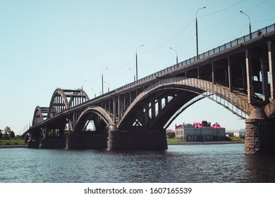 Small Town Beside A River. Small Town On River Bank With Bridge.