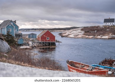 Small town by the sea with old wooden cottages and fishing boat by a rocky shore in Nova Scotia, Canada - Powered by Shutterstock
