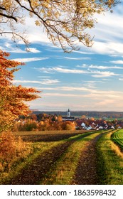 Small Town With Curch. Alps In The Background In Fall. In The Evening