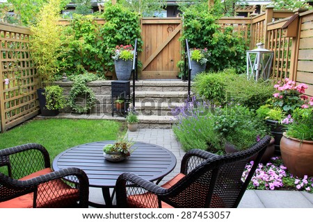 Small townhouse garden with patio furniture amidst blooming lavender. 