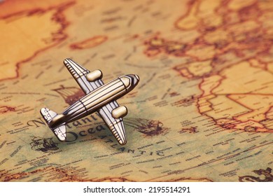 Small Toy Airplane Vintage Classic Old School Style Model Hovering In Take Off Mode Above The Ancient Antique Old-fashioned Style World Map Direct Flight From Left To Up Right Side In The 45 Degree