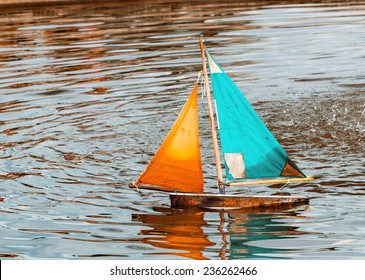 Small Toy Boat Sailing On A Lake.