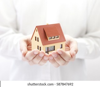 Small toy house in hands 