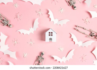 Small Toy House Surrounded By Halloween Decorations On Pastel Pink Background. Flat Lay, Top View.