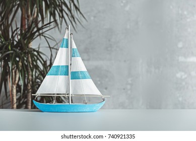 Small Toy Sailboat Is On Desk