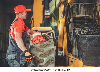 Small Tractor Bulldozer Engine Repair. Caucasian Professional Mechanic And His Job. Heavy Equipment Service Center.