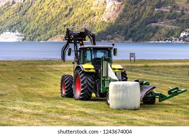 Small Tractor With A Round Bale Wrapper On A Field In Geiranger, Norway.