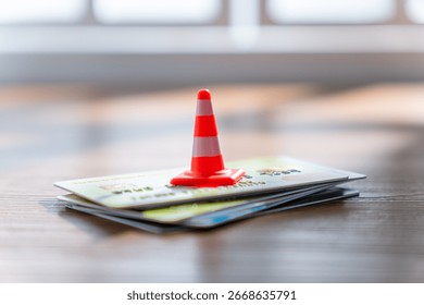 A small traffic cone on a stack of credit cards. Financial caution, security, credit limit and consumer debt concept.
