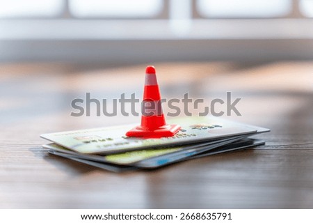 A small traffic cone on a stack of credit cards. Financial caution, security, credit limit and consumer debt concept.
