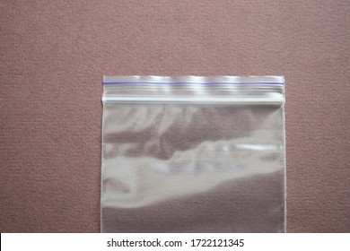 Small Transparent Plastic Bag With Zip Clasp On A Dark Background. The View From Above.