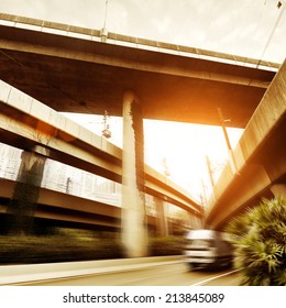 Small Truck Speeding Under Industrial Bridges. Long Exposure, Burred Motion.