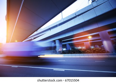 Small Truck Speeding Under Industrial Bridges. Long Exposure, Burred Motion.