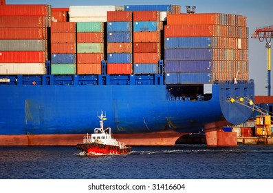 The Small Tugboat Accentuates The Size Of The Large Container Ship Stern Part With Cargo Containers