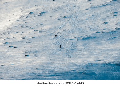 Small Two Mountaineer Hiking On Snow Covered Hill To The Top Of Mountain In Winter 