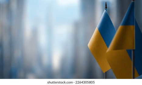 A small Ukraine flag on an abstract blurry background. - Powered by Shutterstock