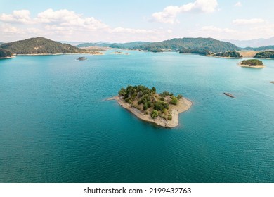 Small Uninhabited, Desert Sand Island With Many Trees In The Middle Of Sea. Drone View, Aerial View, Top View